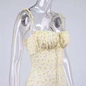 Detail of floral backless maxi dress featuring pleated bust and yellow flower pattern