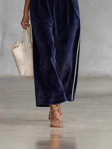 Pantaloni a gamba larga in velluto blu scuro con strisce bianche e texture lucida