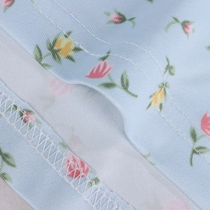 Detailed macro view showing professional double-stitch hem and floral fabric texture
