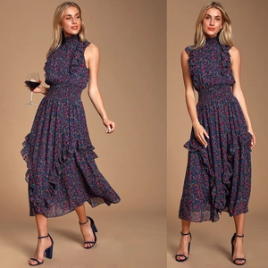 Détail d'une robe fleurie sans manches bleu marine avec volants et taille smockée