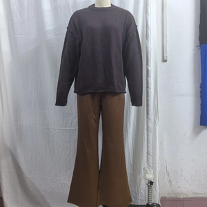 Detail of solid coffee crewneck knit sweater paired with brown wide-leg casual pants