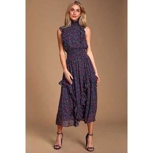 Détail du col montant à volants et imprimé floral sur une robe bleue sans manches