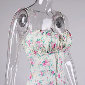 Close-up of floral print dress featuring ruffled chest detail and adjustable tie shoulder straps