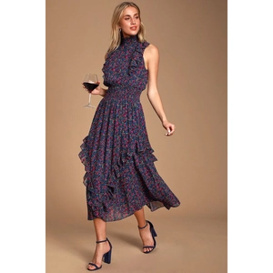 Détail d'une robe midi fleurie avec taille smockée et ourlet à volants superposés