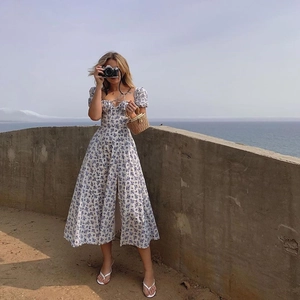 Detail of floral puff sleeve dress with tie front and slit skirt in summer vacation style