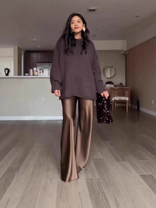 Chic women's oversized brown knit sweater paired with bronze satin wide-leg trousers set