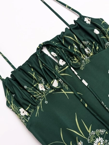 Detail of the ruffle neckline and thin straps on a dark green floral maxi dress