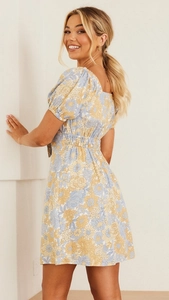 Détail d'une robe mini à manches ballon et motif floral bleu et jaune avec taille haute
