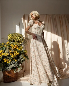 Detail of floral print maxi dress featuring puff sleeves and cross halter neck design