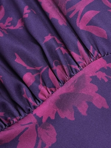 Macro detail of purple floral fabric with intricate pleating and fine mesh texture
