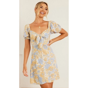 Mini robe d'été fleurie avec manches ballon, décolleté en cœur et nœud à l'avant