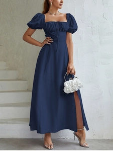 Dettaglio di abito blu navy con maniche a sbuffo e spacco laterale profondo