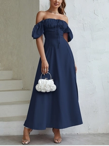 Dettaglio di un abito blu navy con spalle scoperte, maniche a sbuffo e spacco laterale