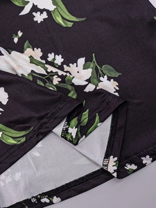 Macro detail of the floral print fabric and durable double-stitched hem on the long dress