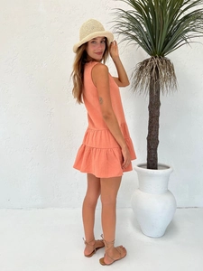 Detail view of coral orange sleeveless mini dress featuring multi-layered tiered skirt