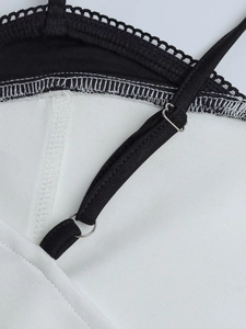 Detail view of adjustable black straps and delicate lace trim on floral slip dress