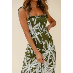 Detail of tropical palm print on dark green jumpsuit with ruffled shoulder straps