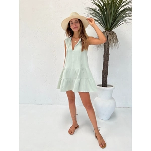 Detail of mint green sleeveless tiered sundress featuring V-neckline and drawstring ties