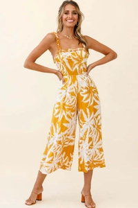 Detail of ruffle neckline and palm leaf print on ginger yellow bohemian jumpsuit
