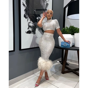 Dettaglio del crop top in paillettes argento e gonna a matita con piume di struzzo sul bordo
