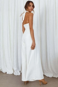 Elegant white halter neck jumpsuit with an open back and bow tie detail