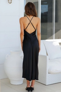 Detailed back view of a black satin maxi dress featuring elegant cross straps and an open back