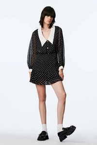 Detail of retro black polka dot chiffon dress with white pointed collar and sheer sleeves