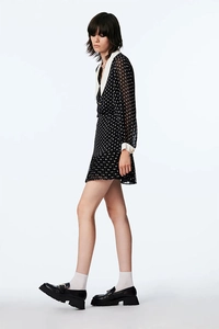 Side view of a vintage polka dot chiffon dress featuring white collar and retro cuffs