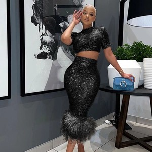Completo due pezzi con paillettes nere top corto e gonna midi con orlo in piume da festa