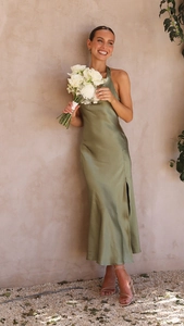 Détail de la robe en satin vert sauge avec fente latérale et texture soyeuse