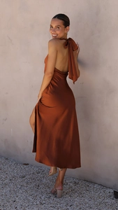 Détail d'une élégante robe midi en satin dos nu avec un grand nœud papillon au cou
