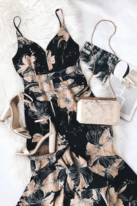 Flat lay of a floral V-neck midi dress with golden chain bag and sandals on plush rug