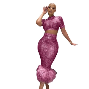 Elegante set di due pezzi di paillettes con crop top a maniche corte e gonna con piume