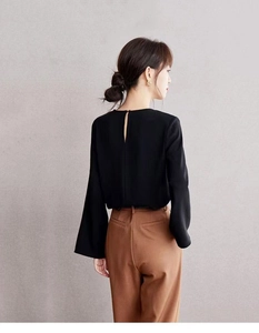 Elegant black long sleeve blouse with back slit button detail and high waist brown trousers
