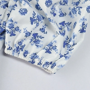 Detail of smocked elastic cuff on white and blue floral print chiffon dress sleeve