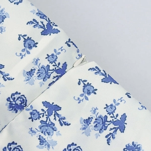 Detail of invisible side zipper closure on blue floral print French slit maxi dress