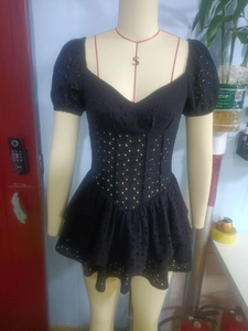 Detail of black puff sleeve dress featuring hollow embroidery and tiered cake skirt texture