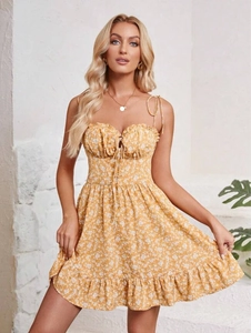 Detail of yellow floral mini dress with ruffled neckline and delicate tie-up bow
