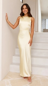 Detail of sleek pale yellow satin fabric and backless design on long fishtail dress