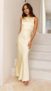Detail of elegant pale yellow satin fishtail dress with silky texture and backless design