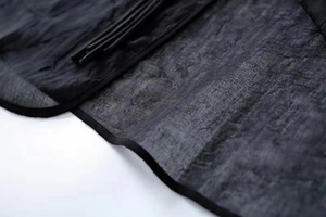 Macro shot of dark grey textured linen fabric with precision zipper and piping detail