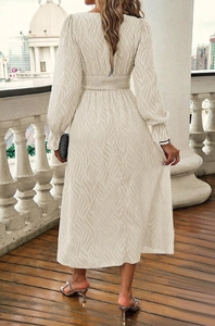 Detail of smocked waist and wave texture on cream long sleeve midi dress from the back