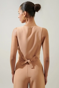 Detail der kamelfarbenen Weste mit V-Ausschnitt am Rücken und eleganter Taillenschleife