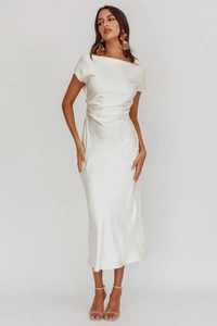 Détail de la robe en satin blanc cassé montrant la texture lisse et les plis de taille