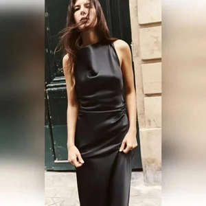 Detailaufnahme der glänzenden schwarzen Satin-Stoffstruktur und des Seitenreißverschlusses