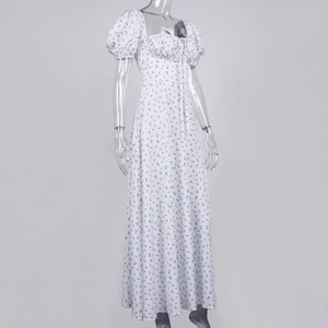 Detailed view of white floral dress with blue patterns, square neck and puff sleeves