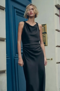 Detail eines eleganten schwarzen Satin-Midikleids mit Wasserfallausschnitt und ärmellos