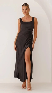 Detail of high-slit hem on a premium black satin dress with elegant draped fabric