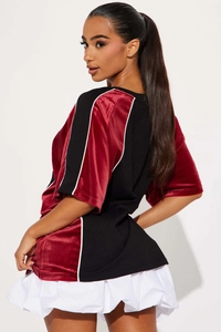 Detail of burgundy and black color block T-shirt with contrast stitching and velvet texture