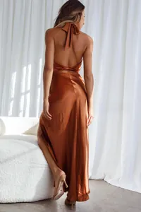 Detail of elegant satin halter dress with backless twist and high side slit feature